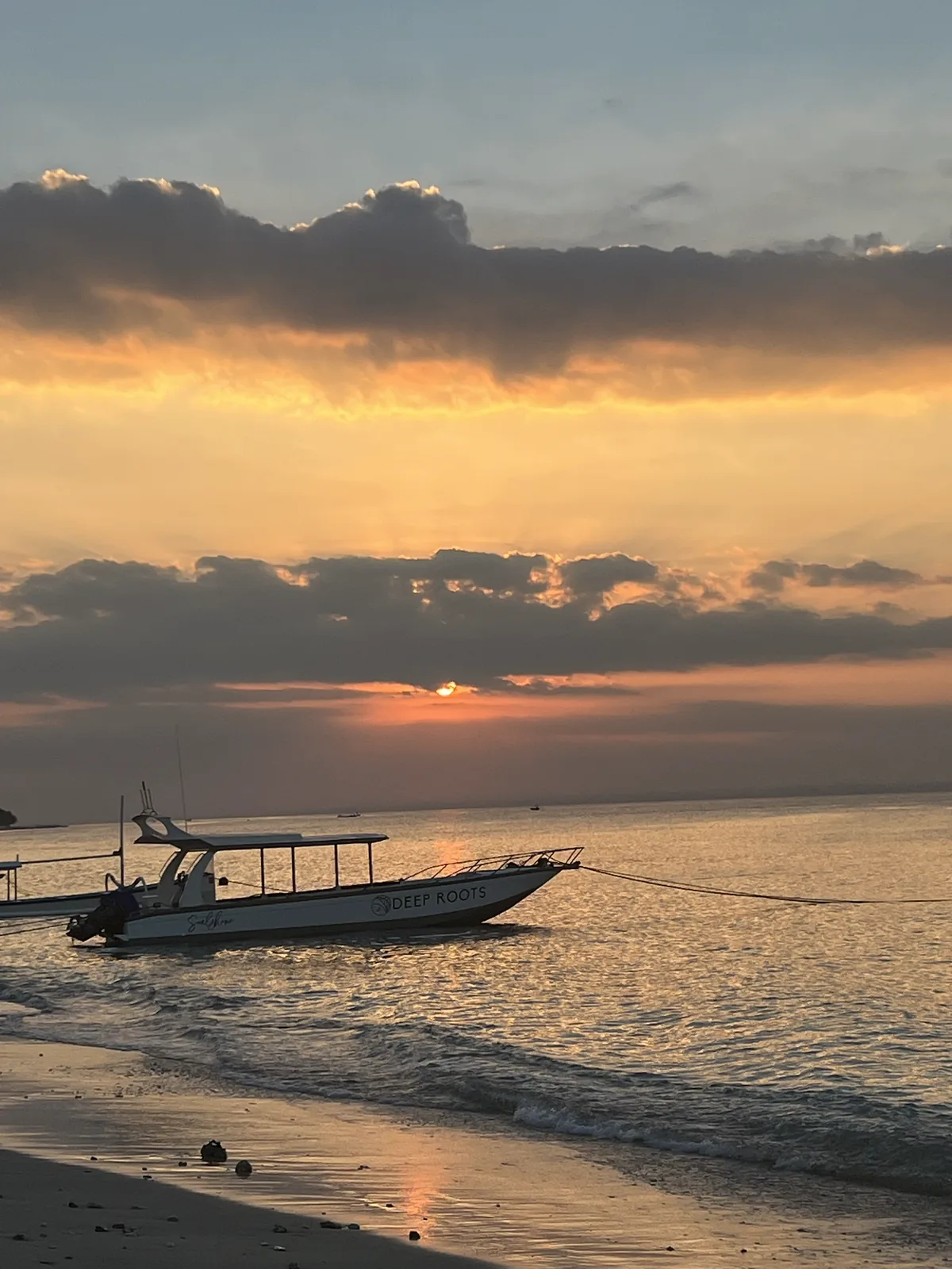 A traditional boat beached on the sand at dusk