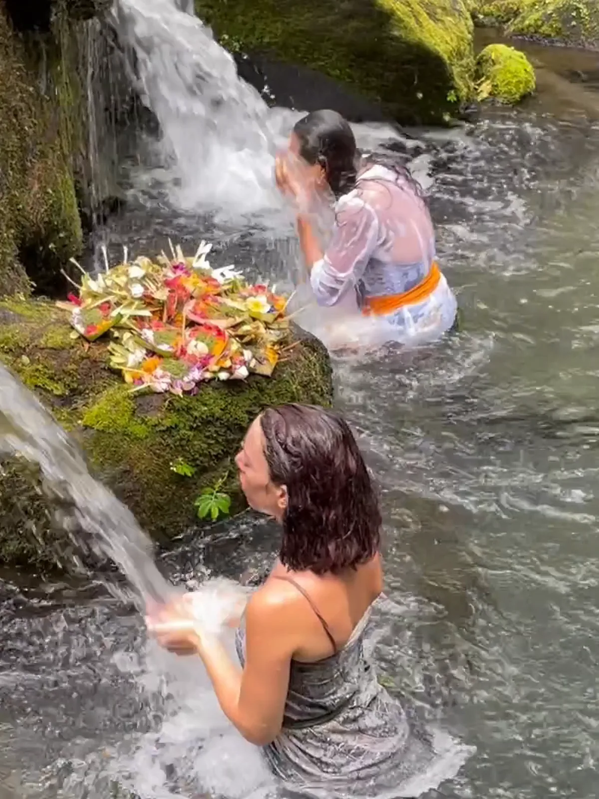 Women purify themselves under the jets of a sacred Balinese spring, the melukat ritual