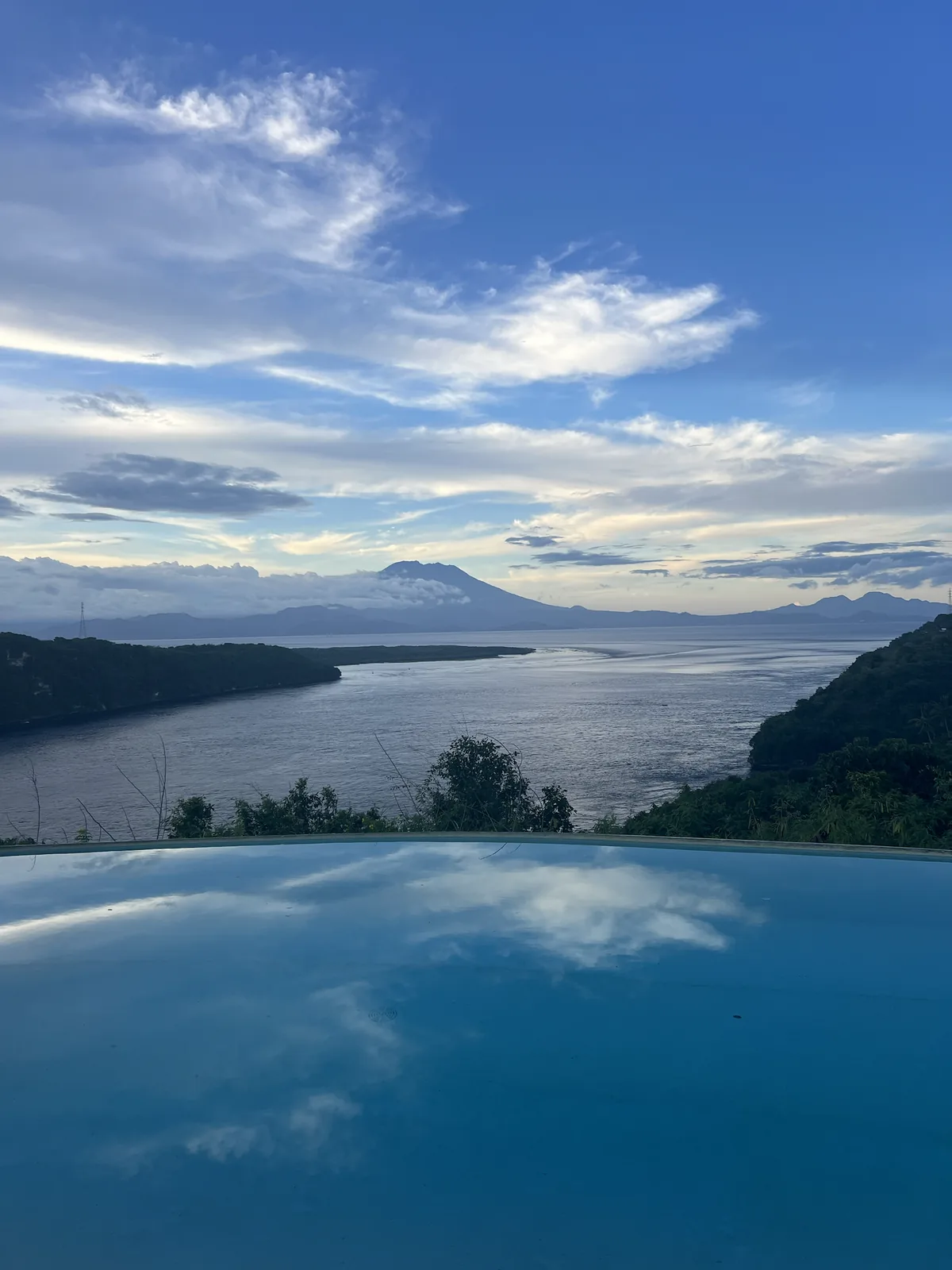 View of the sea from an infinity pool, the volcano on the horizon