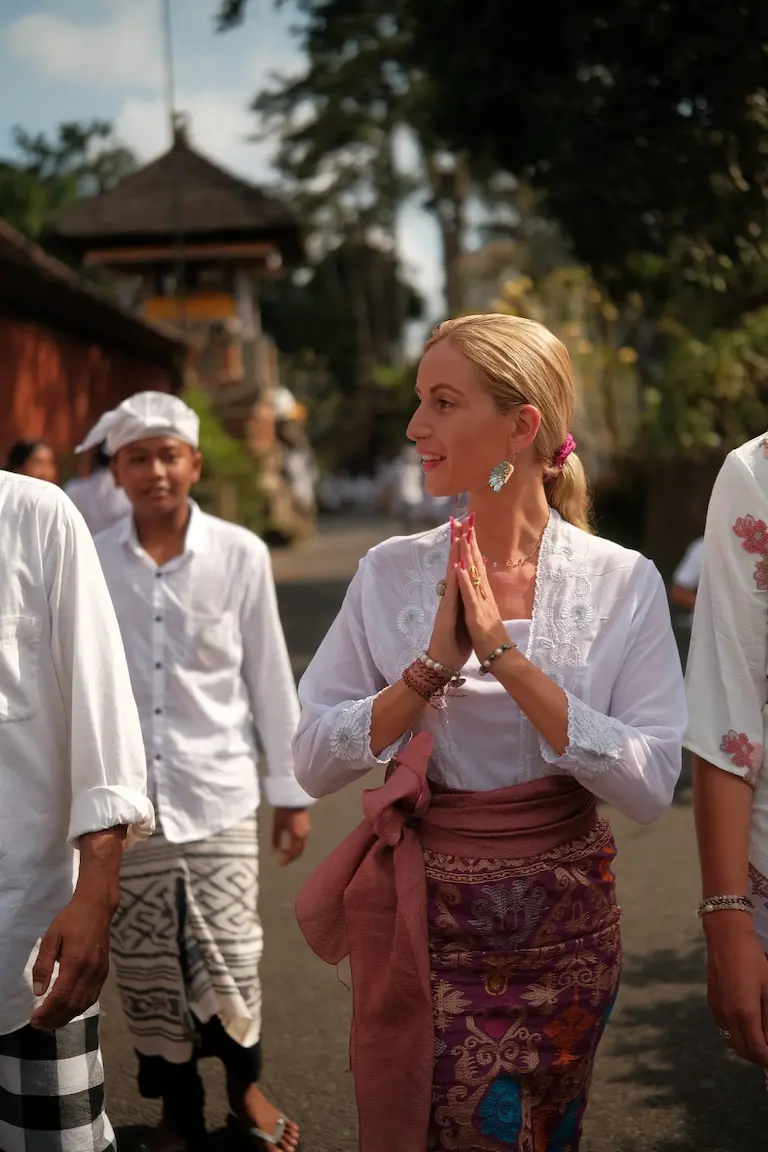 Camille, hands joined, during a Balinese ceremony at the temple